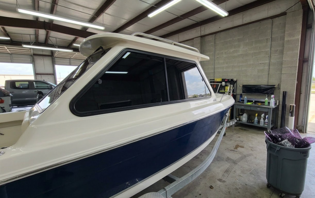 Blue-and-wood boat cabin interior with cushioned seating viewed through a window