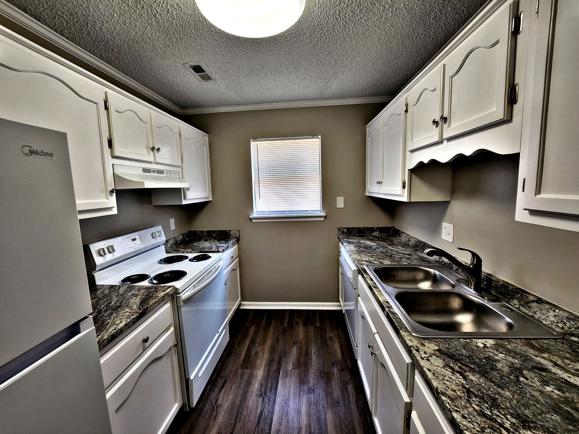 A kitchen with white cabinets and granite counter tops