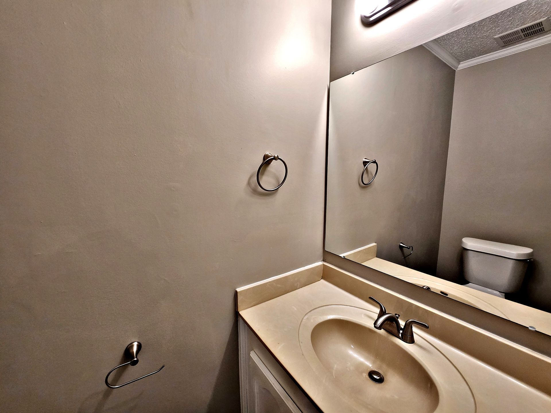 A bathroom with a sink a toilet and a mirror