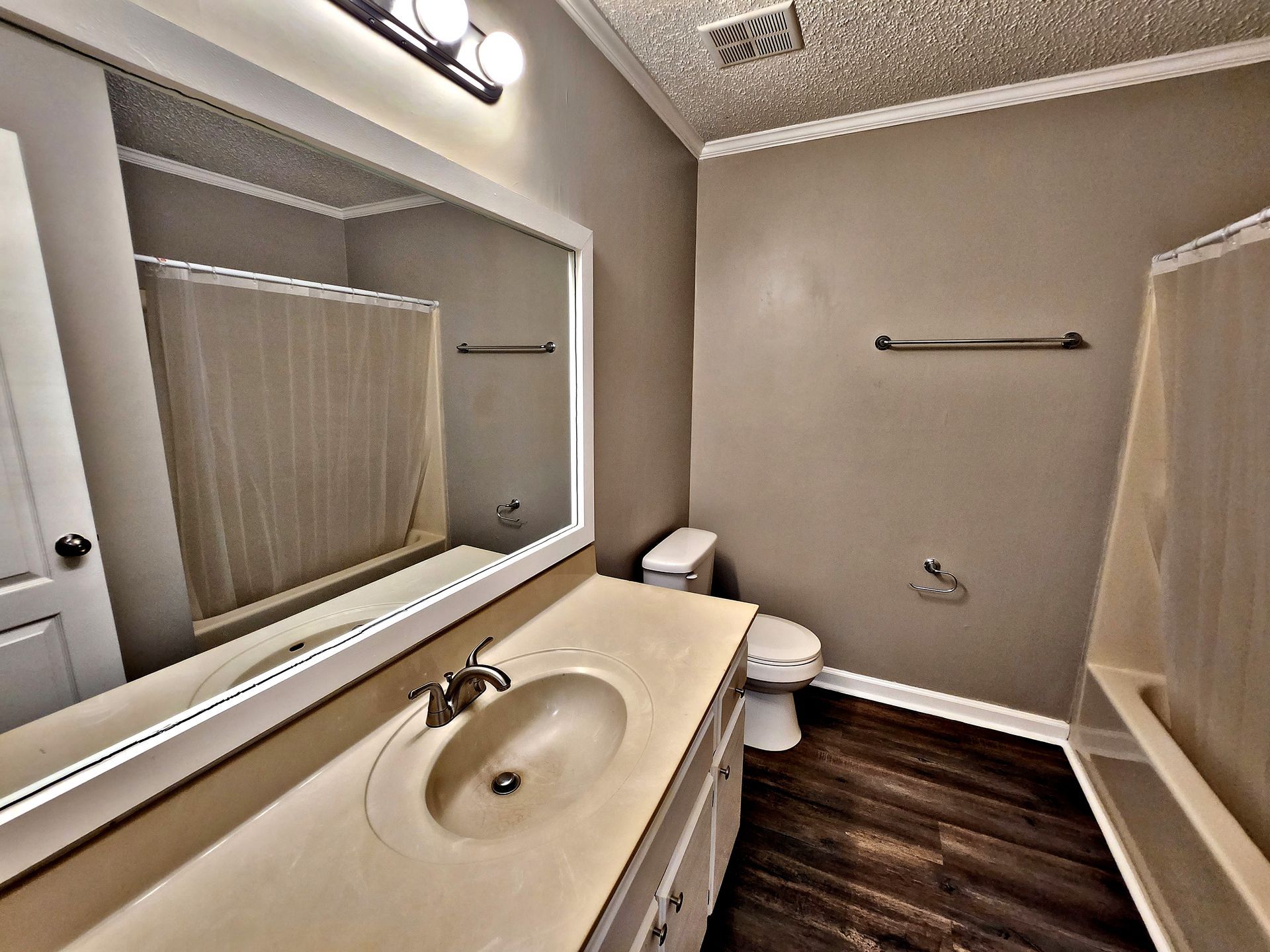 A bathroom with a toilet , sink , and mirror
