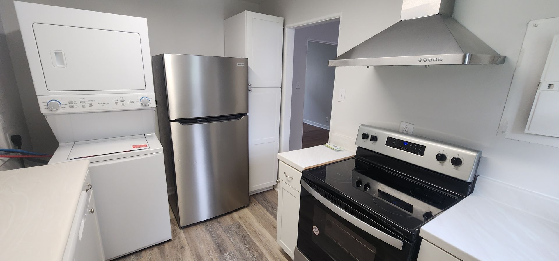 A kitchen with a refrigerator , stove , and washer and dryer.