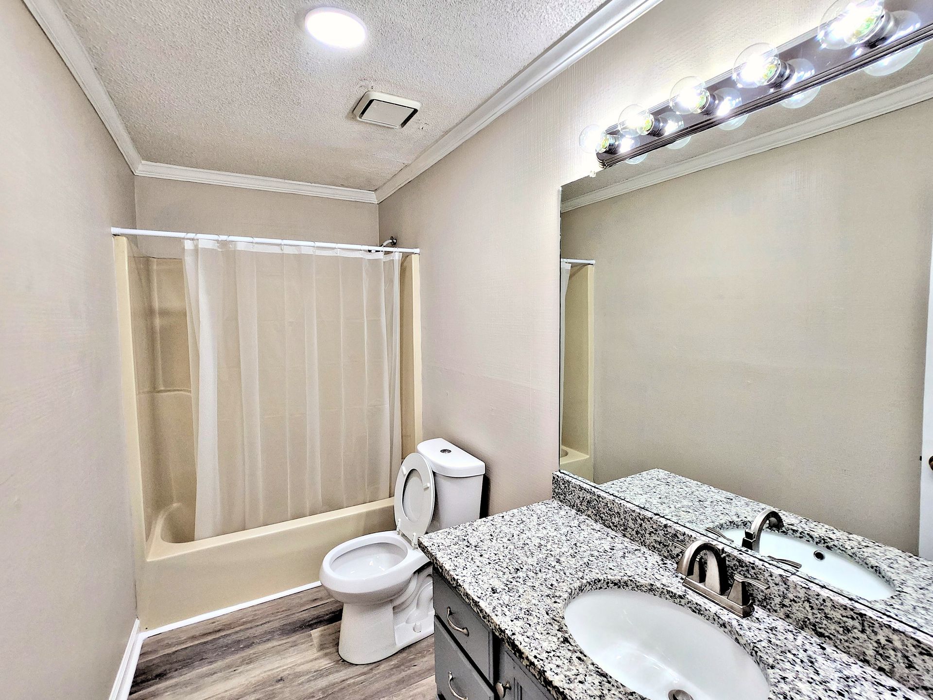 A bathroom with a toilet , sink , and shower.
