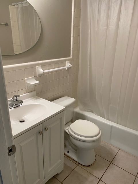 A bathroom with a toilet , sink , and shower.