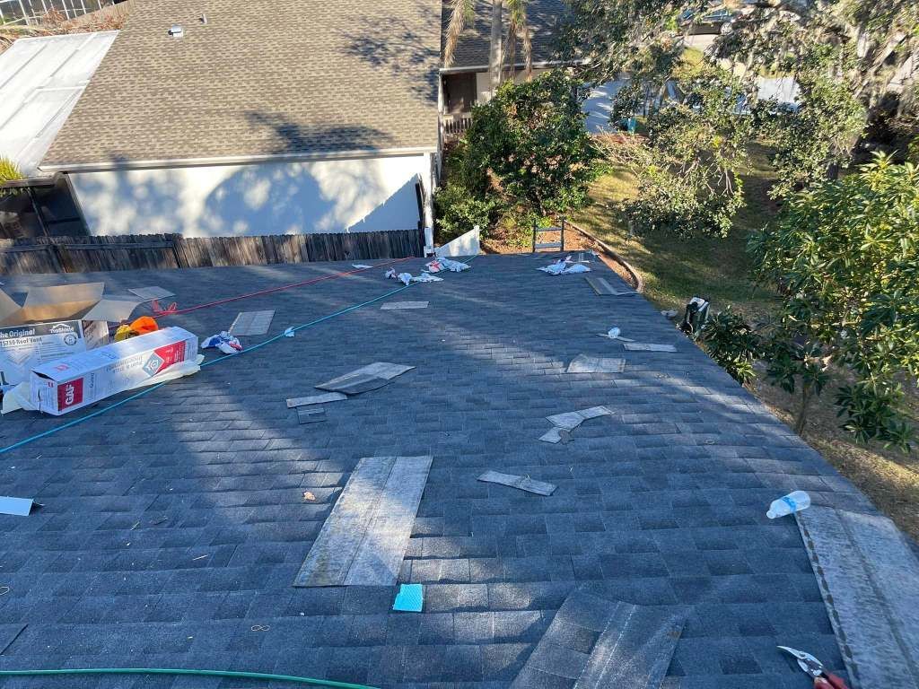A roof with a lot of shingles on it is being repaired.