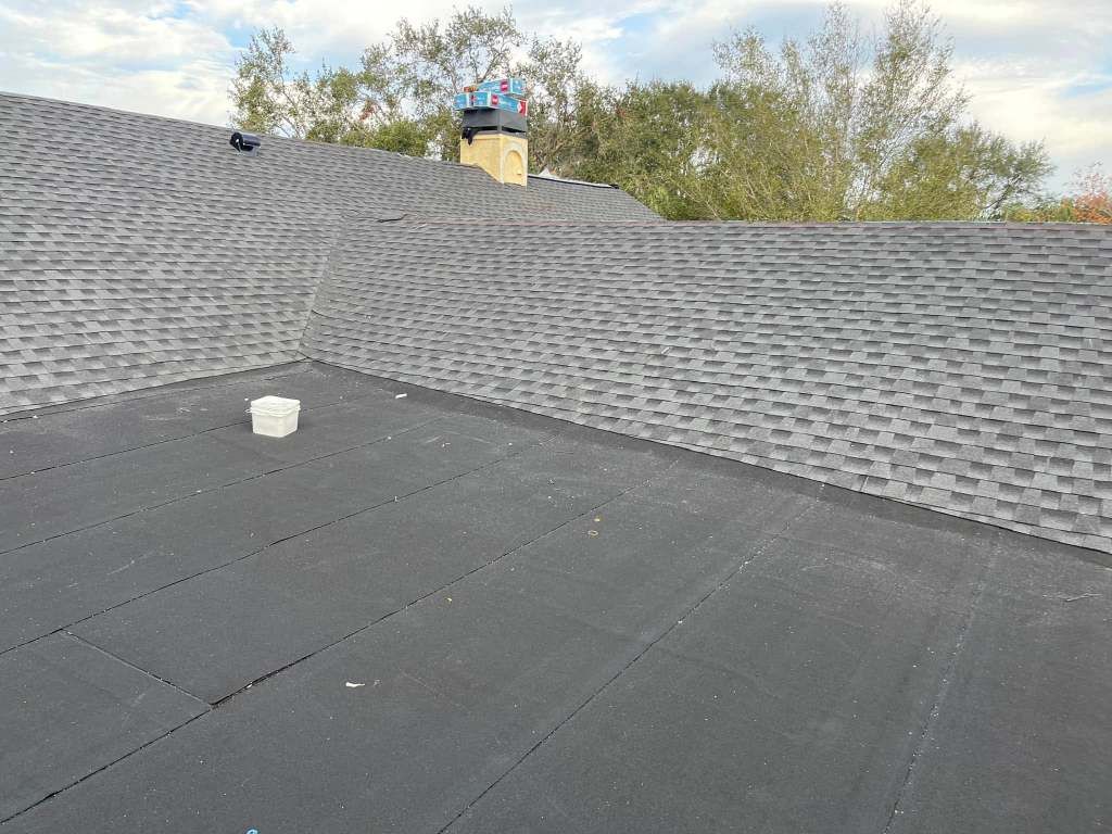 A black roof with a chimney on top of it.