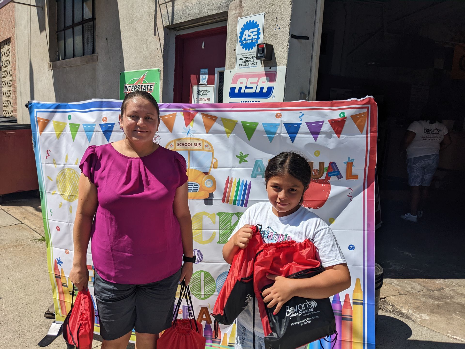 Parent with Student with Banner Behind | Bovan's Auto Services