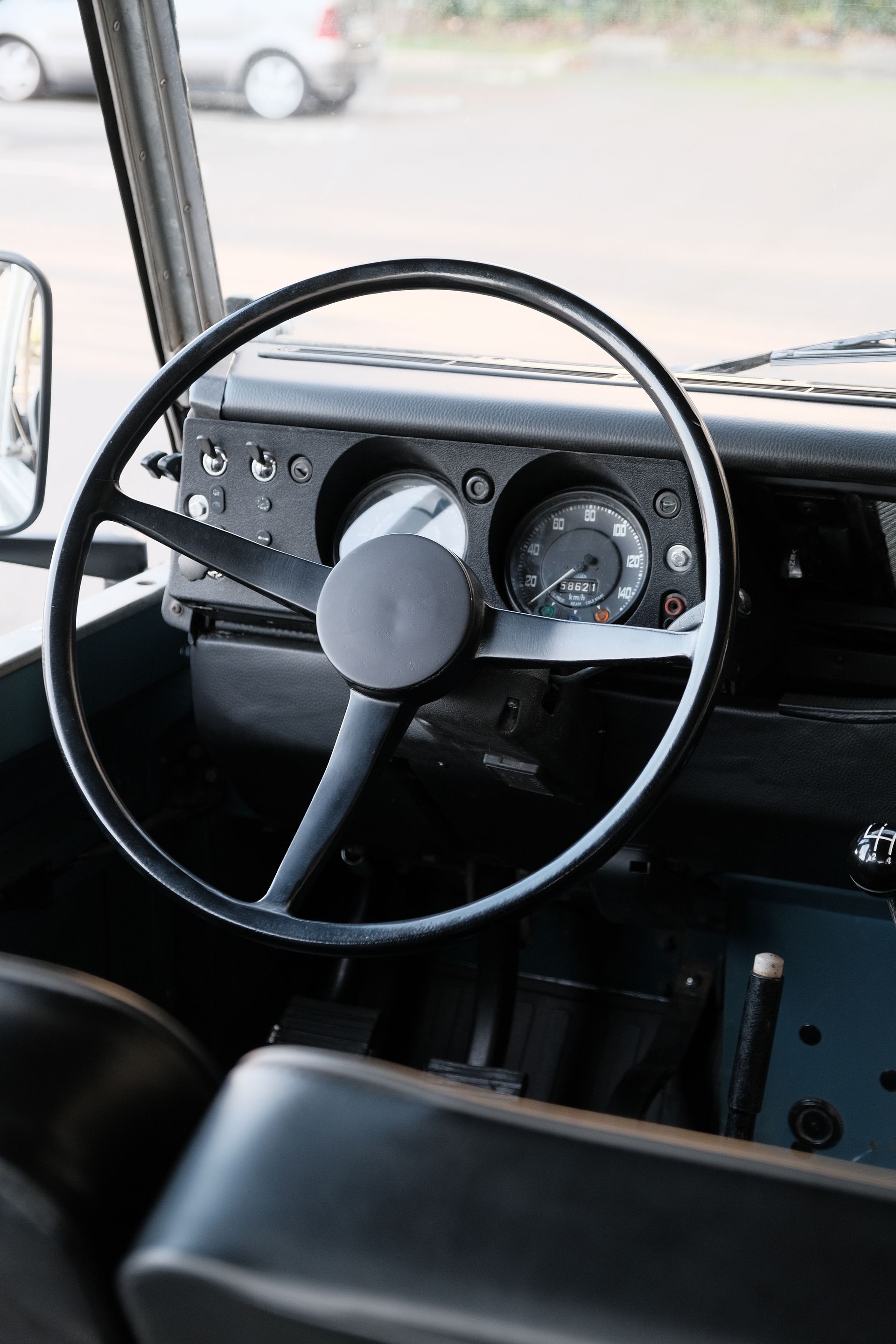 Volant et tableau de bord noirs d'un Land Rover vintage.