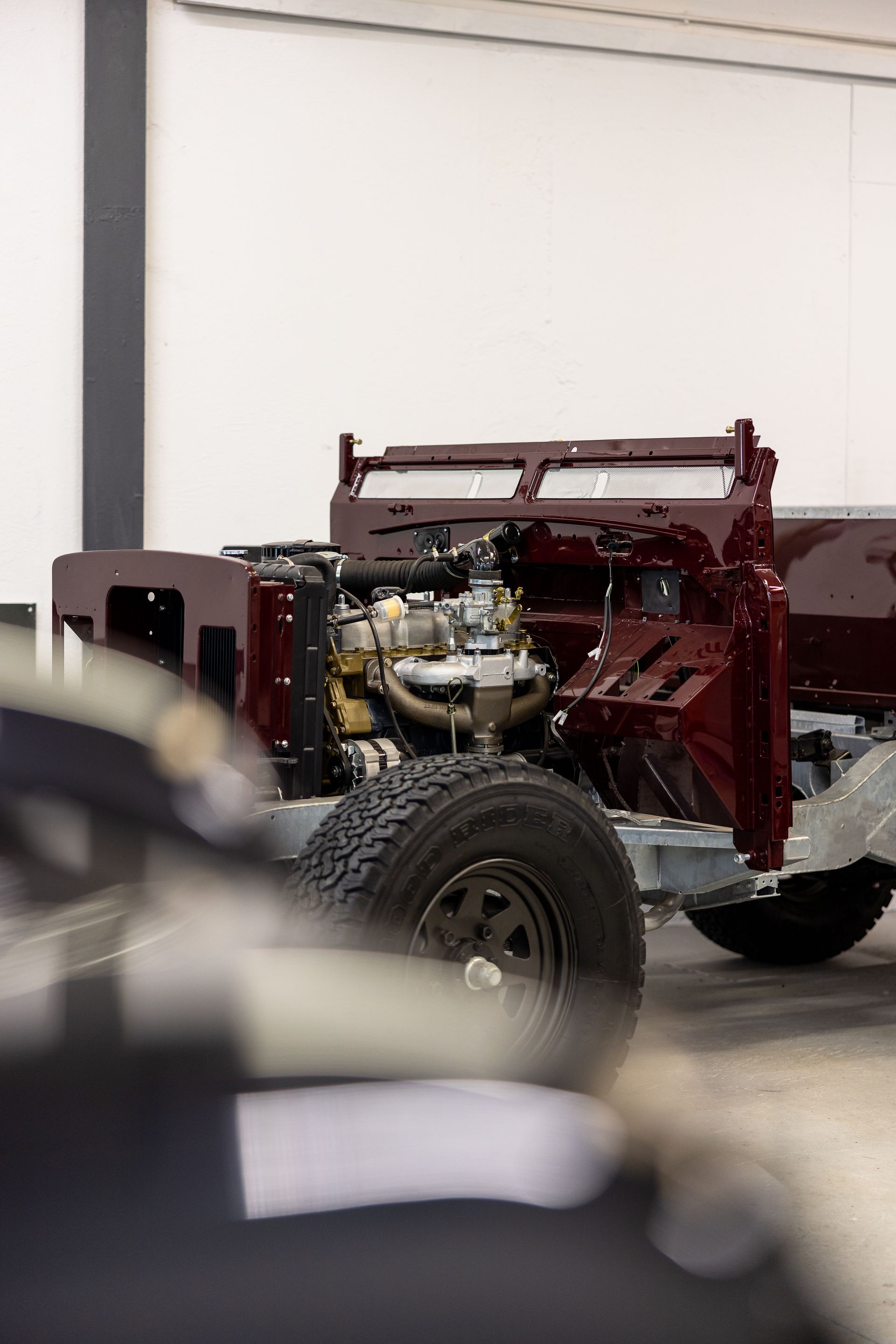 Châssis de camion rouge avec moteur et pneu dans un intérieur lumineux.