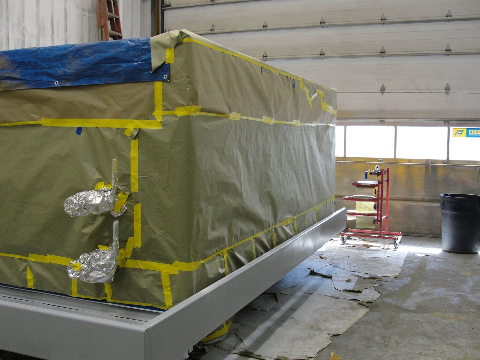 A large container is taped to a wall in a garage
