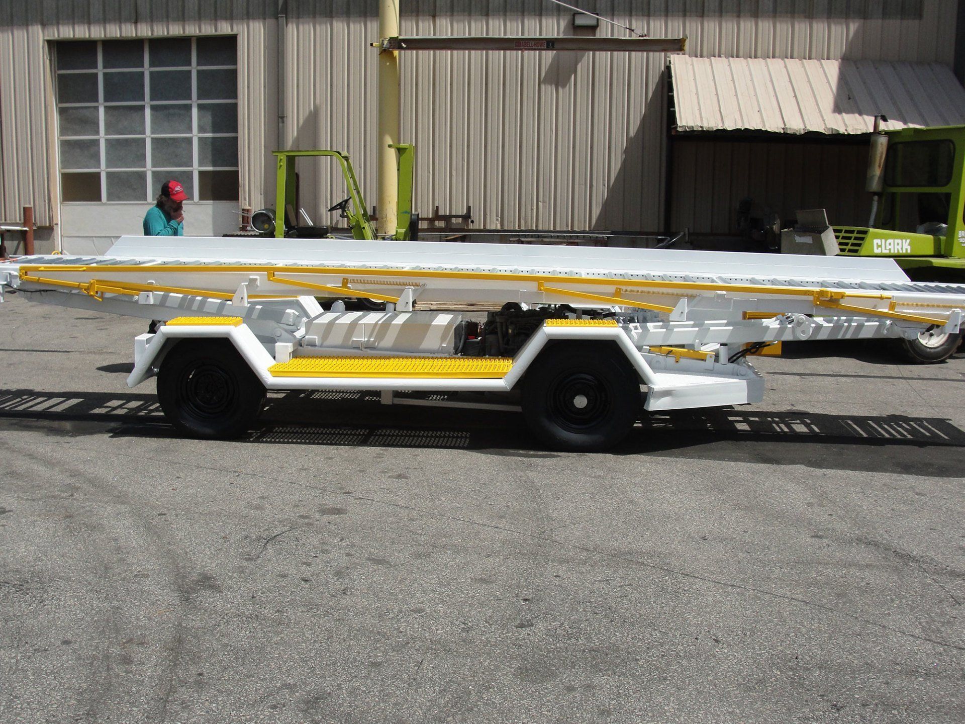A white and yellow trailer is parked in front of a building