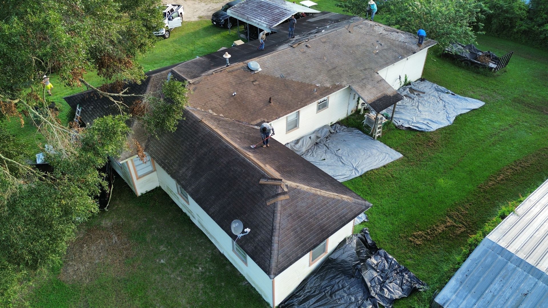 An aerial view of a house with a roof being repaired.