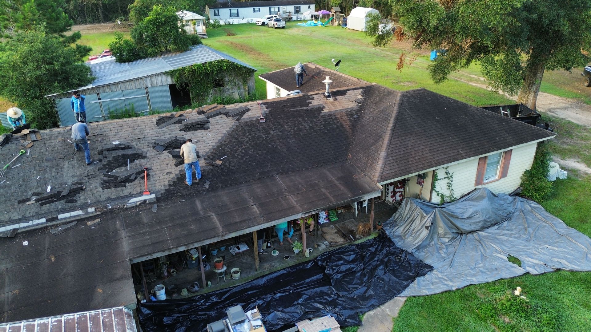 A group of people are working on the roof of a house.