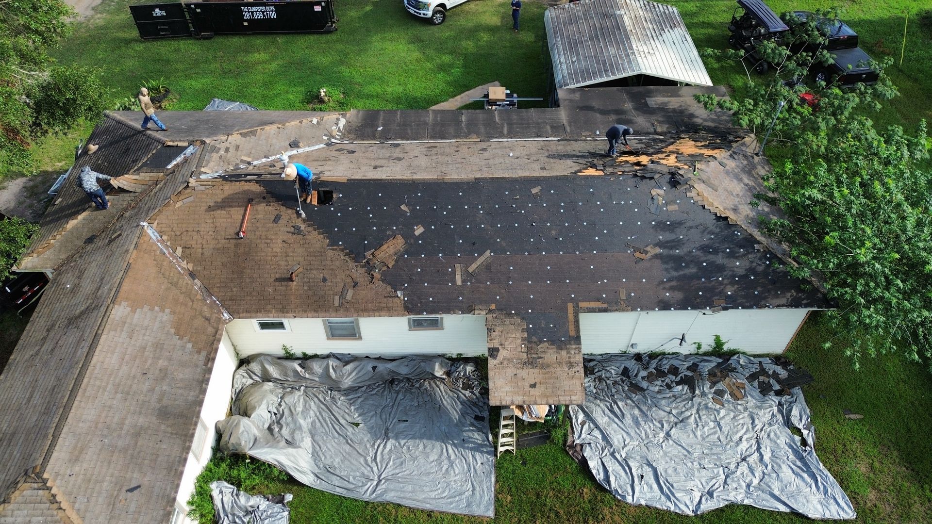An aerial view of a house with a roof that is being repaired