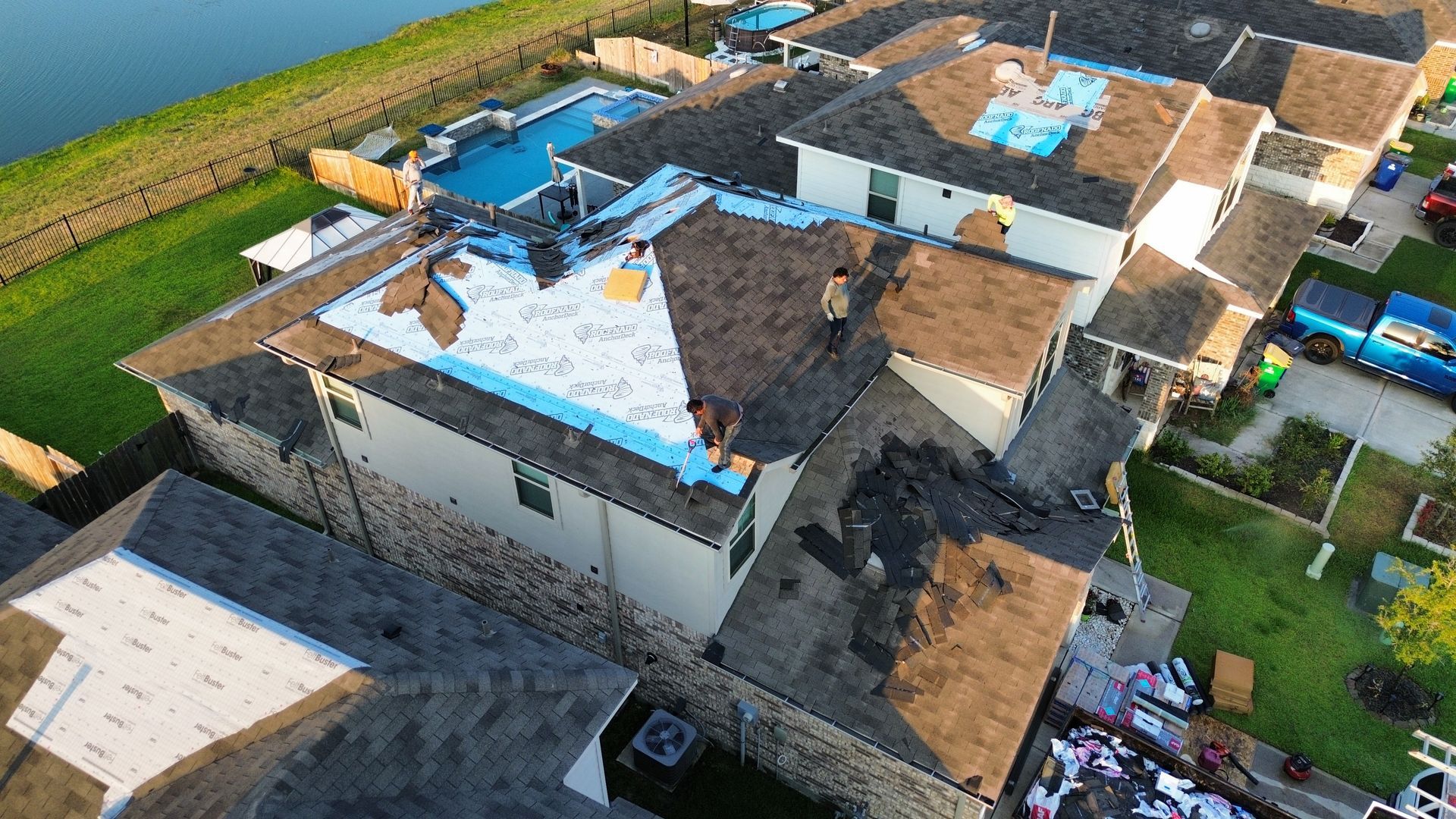 An aerial view of a house under construction with a roof being installed.