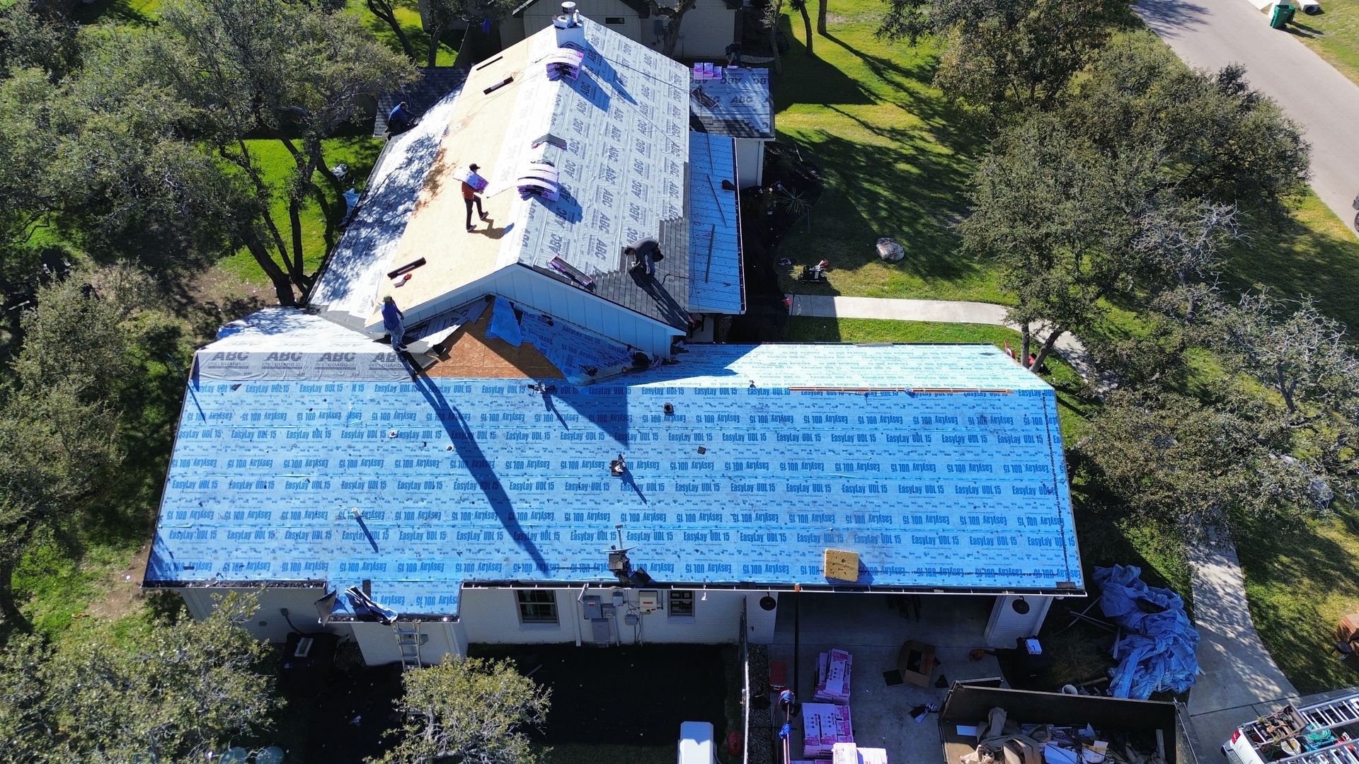 An aerial view of a house under construction with a blue roof.