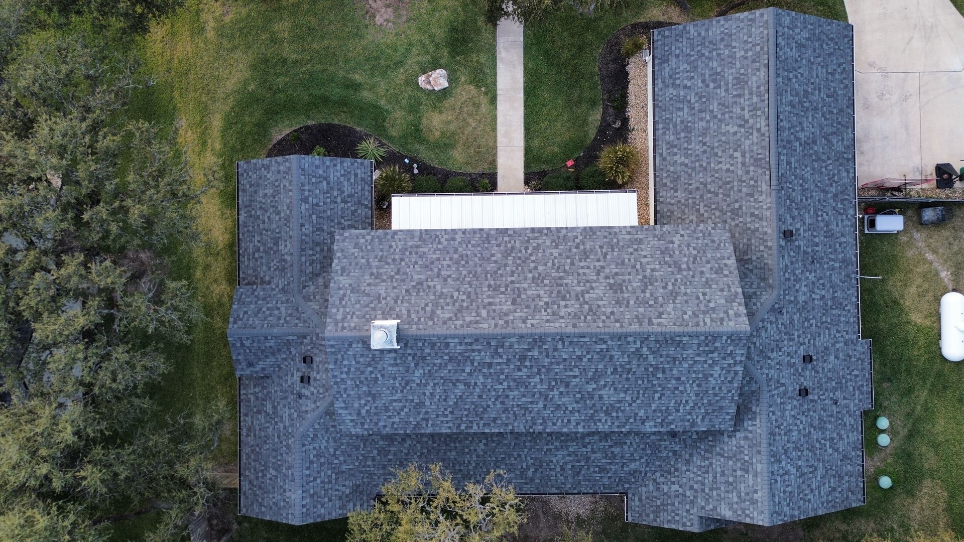 An aerial view of a house with a roof and a chimney.