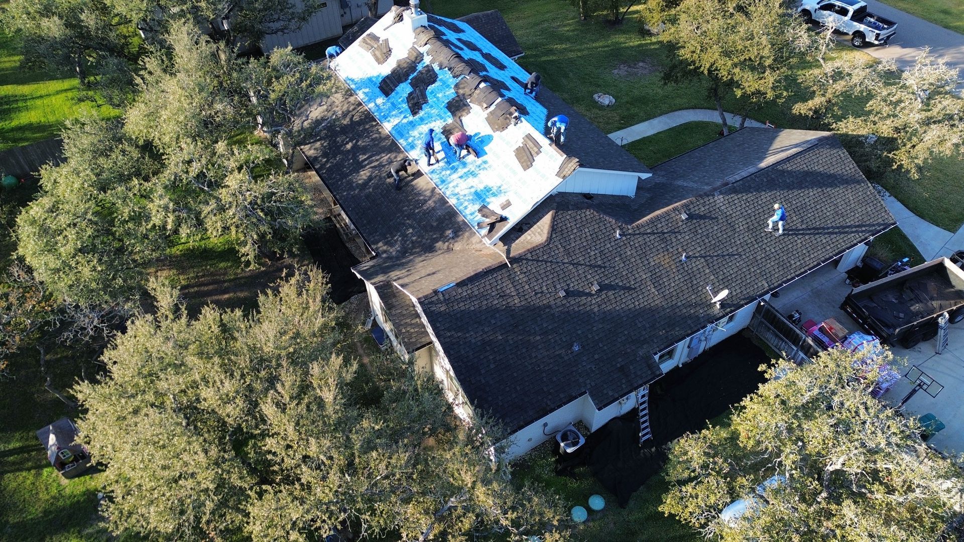 An aerial view of a house with a roof that is being repaired.