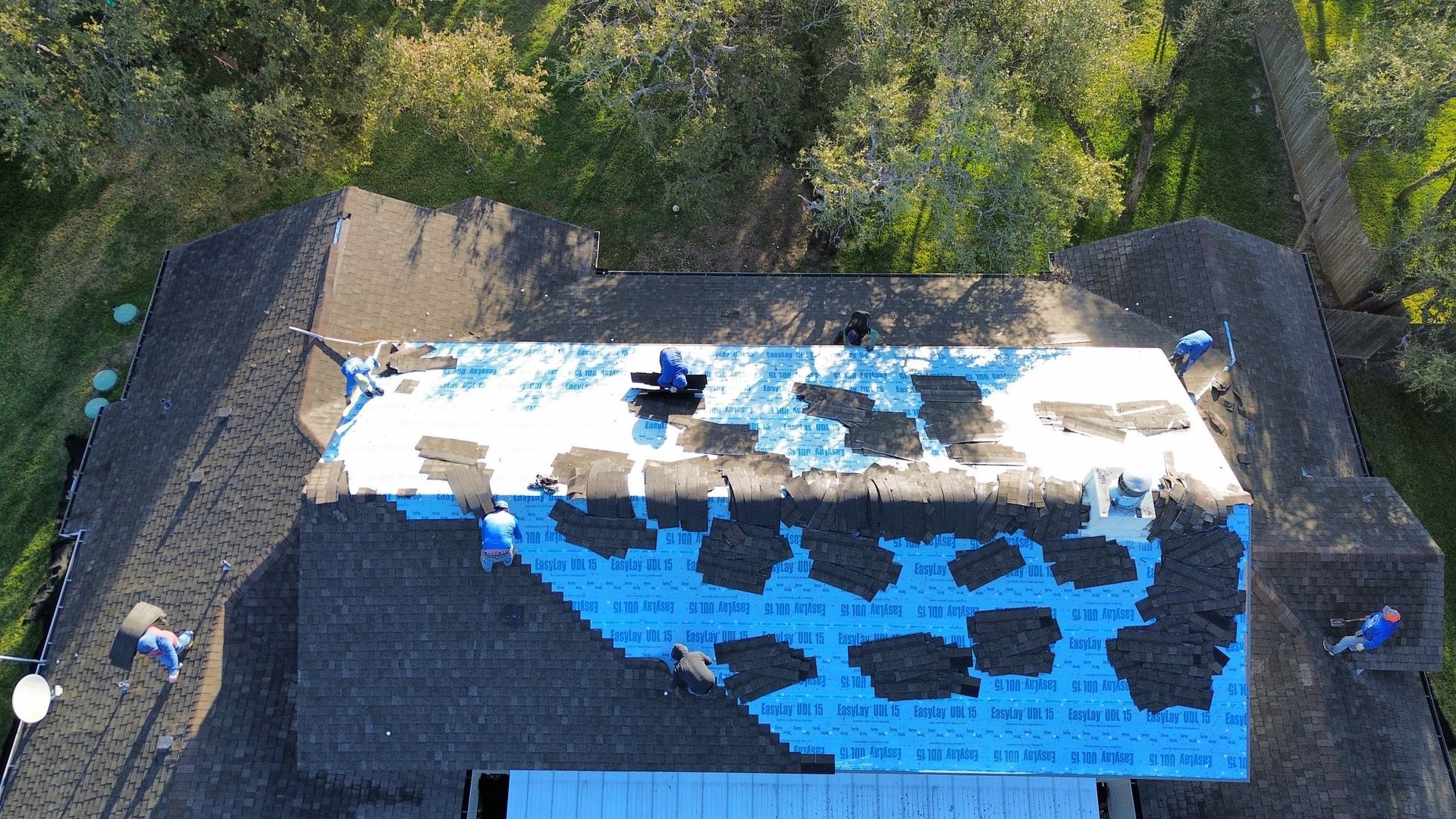 An aerial view of a roof being repaired by a roofer.