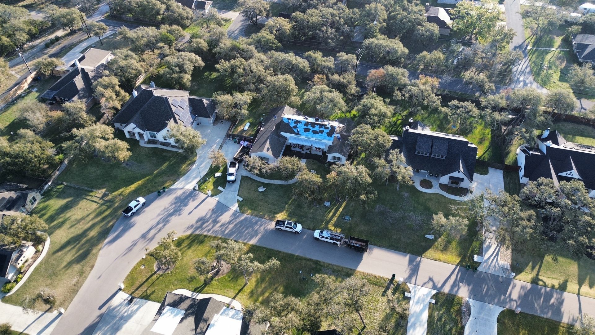 An aerial view of a residential area with houses and trees