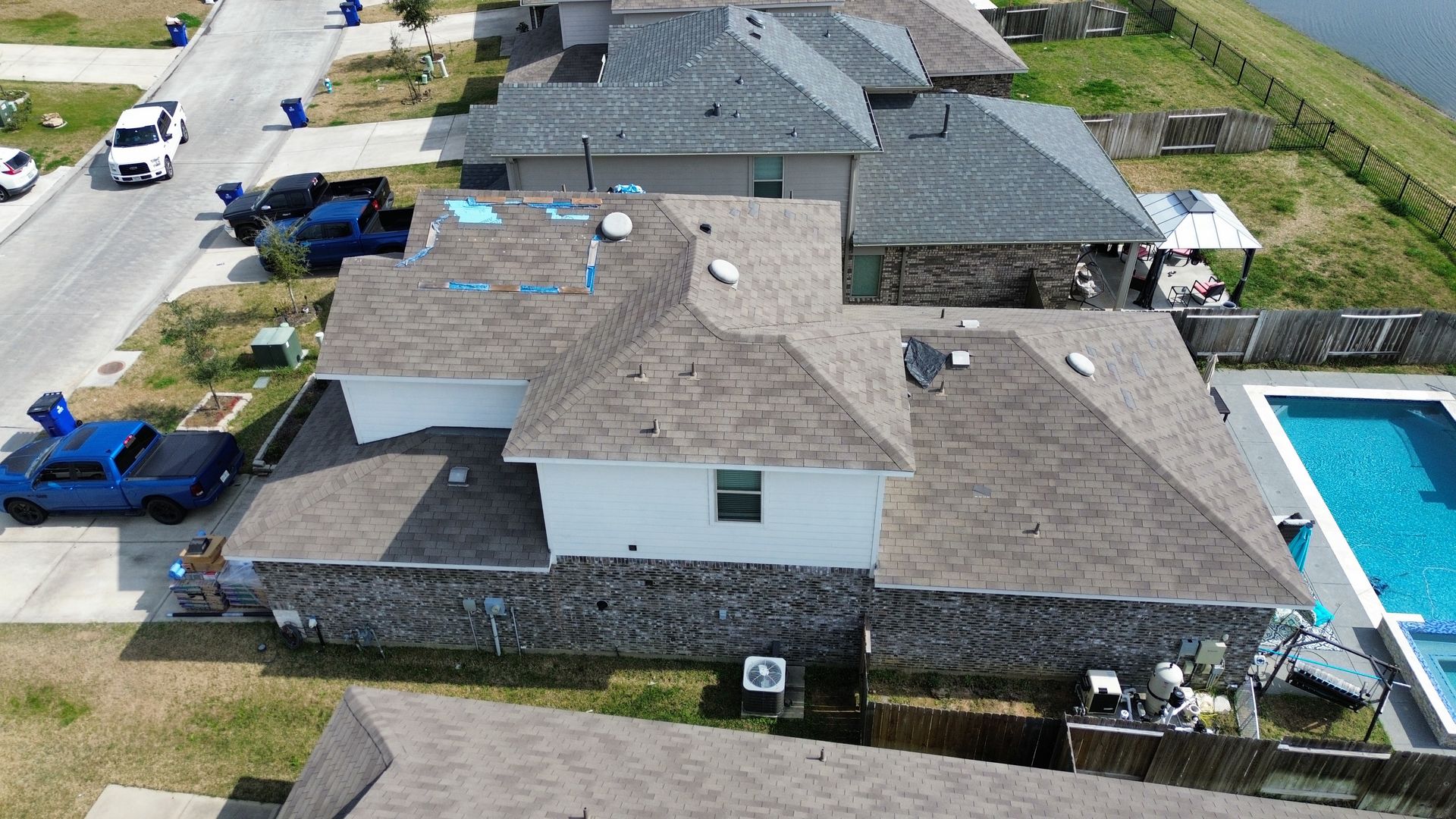 An aerial view of a house with a pool and a truck parked in front of it.