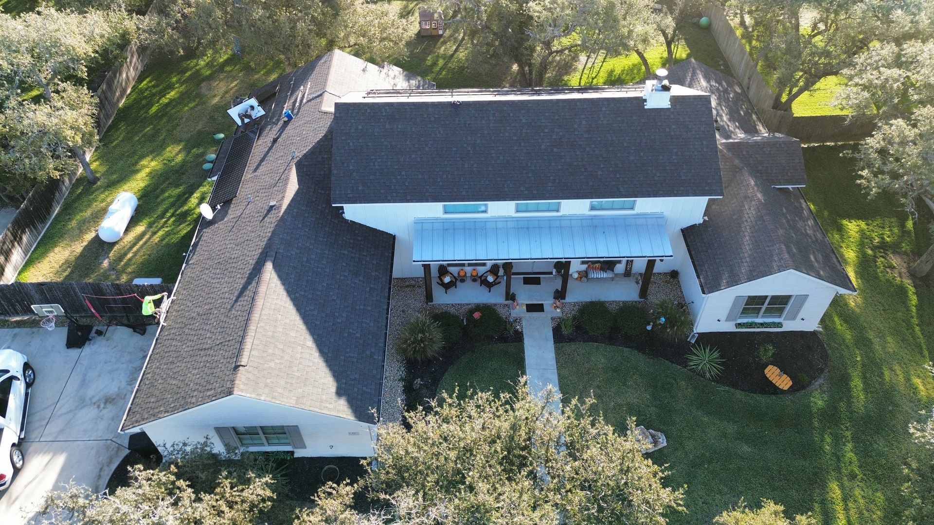 An aerial view of a house with a black roof