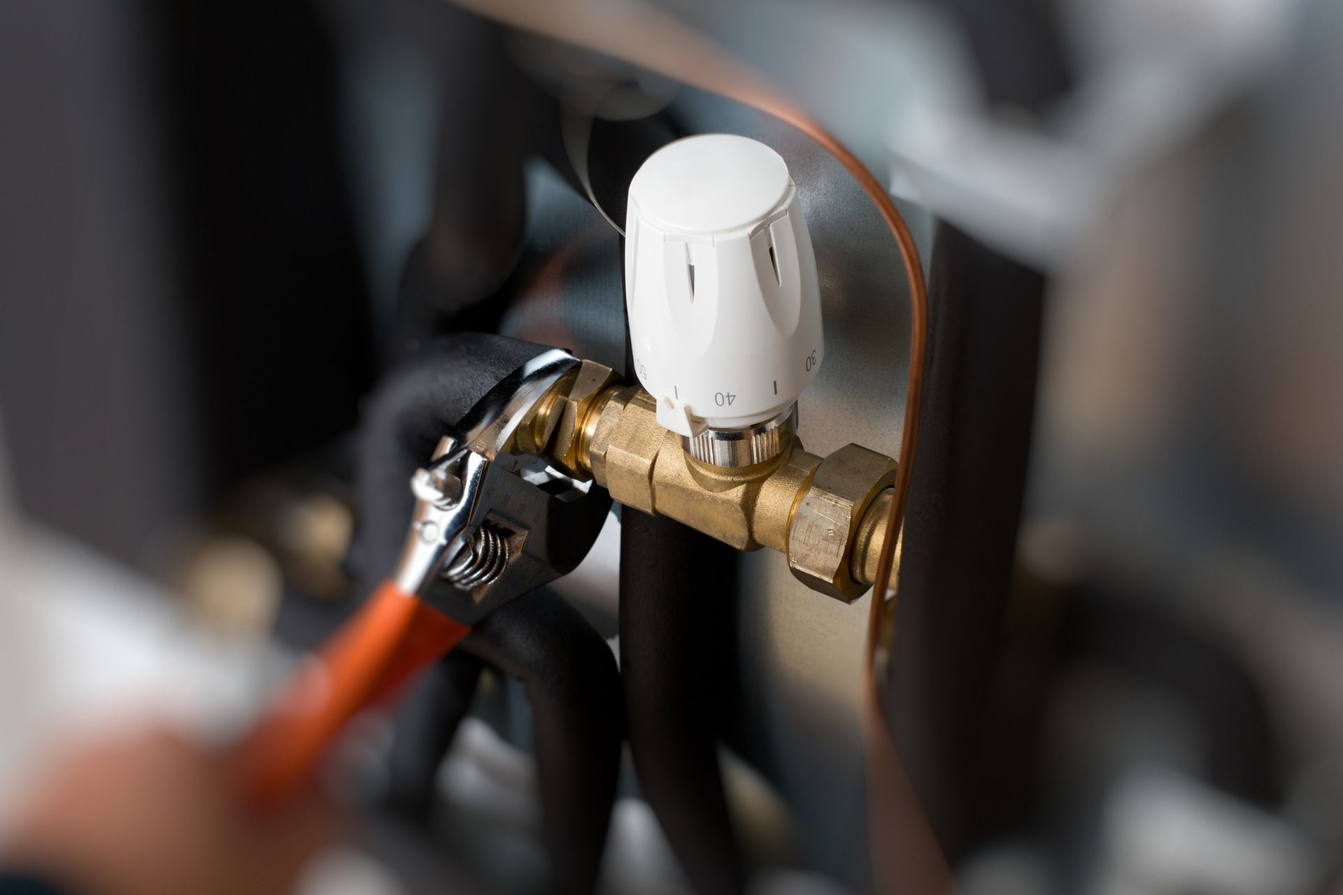 Worker hands fixing heating system — Ringwood, VIC — Dickson Plumbing