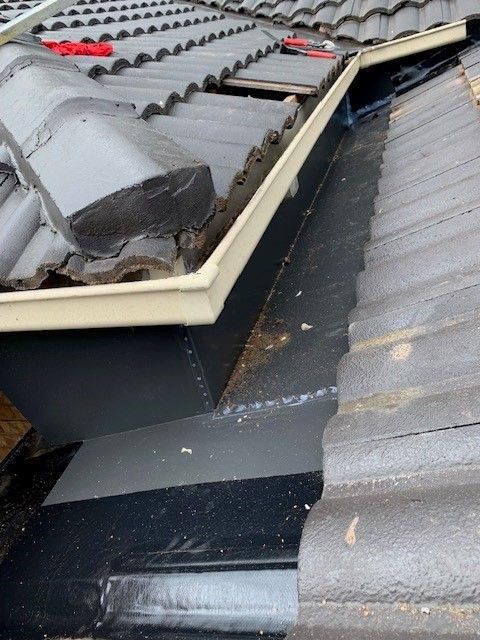 Roof gutter and tiles. The gutter is damaged and needs repair.