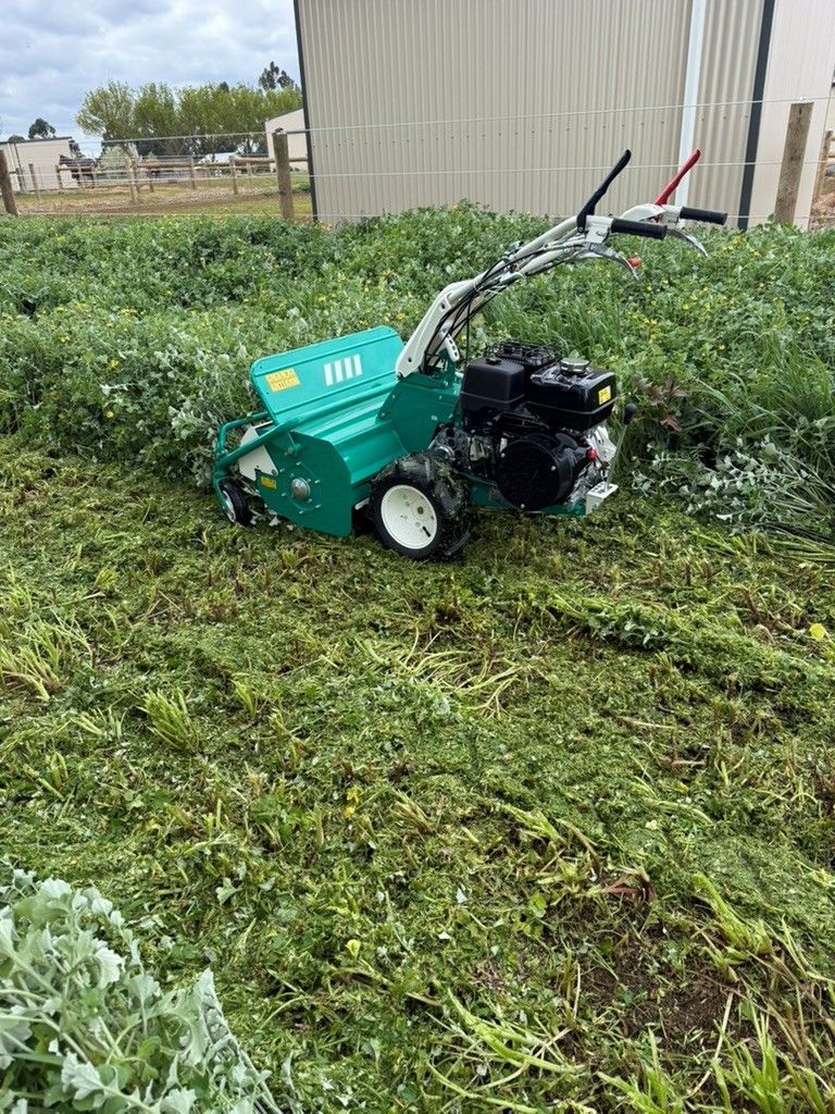 Overgrown grass being mulched with specialist mowing equipment