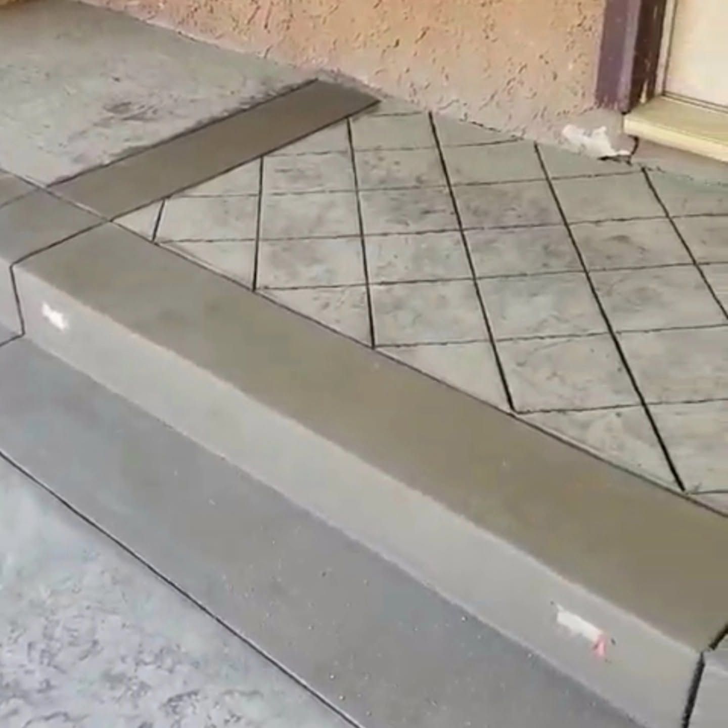 Concrete ramp beside a tiled doorway on a covered porch