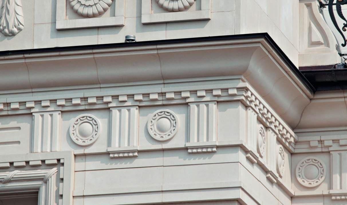 Ornate white building facade with decorative moldings and circular medallions