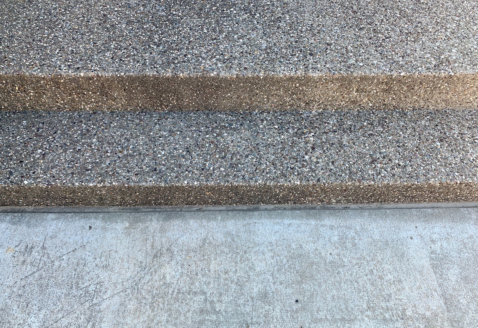 Close-up of gray concrete steps with a brown strip near the top edge