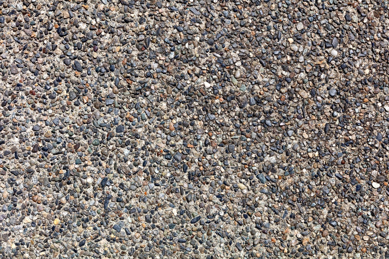 Close-up of a textured gravel surface with small pebbles in gray, tan, and brown tones