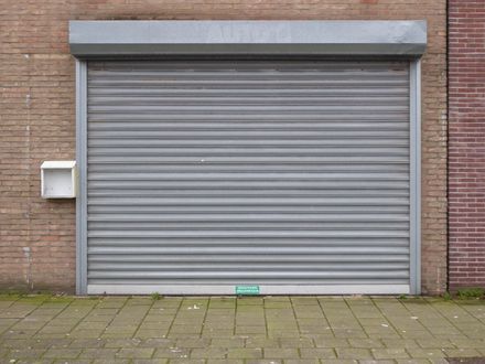 Closed gray roll-up garage door on a brick building exterior