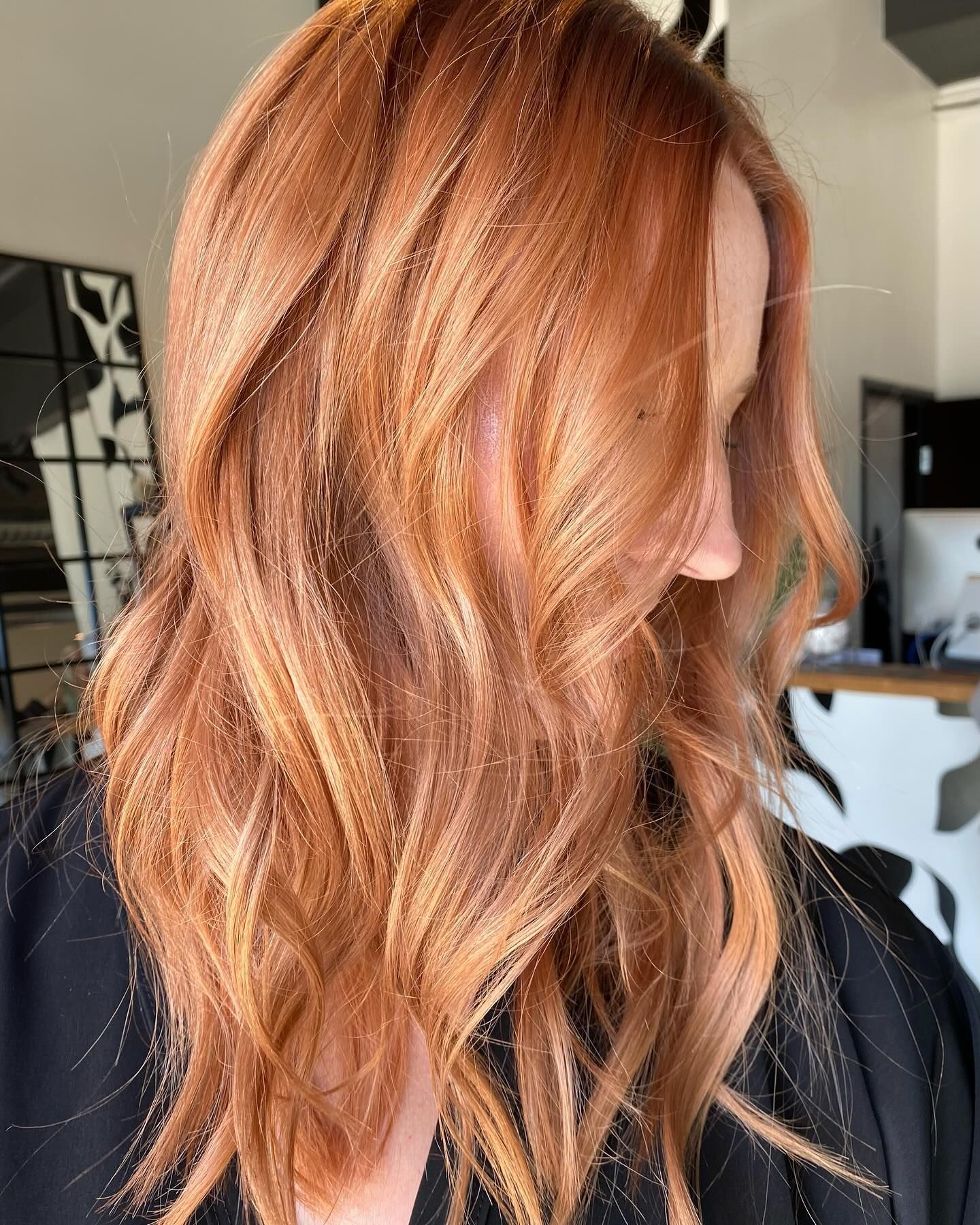 A woman with long red hair is wearing a black shirt.