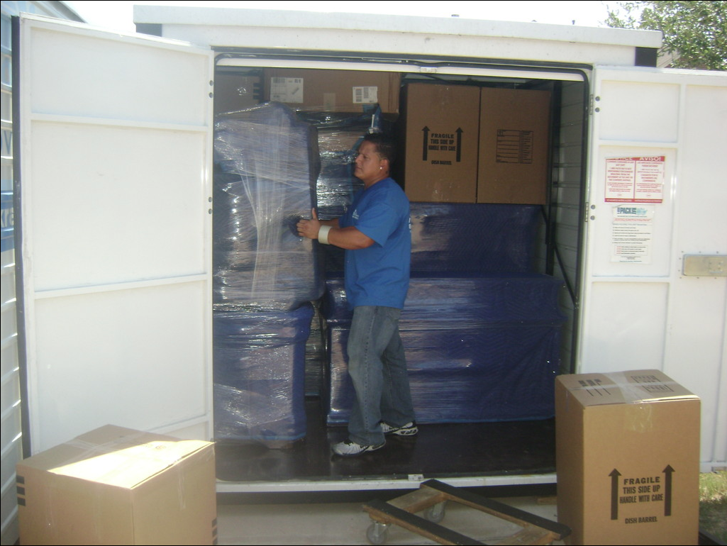 man arranging sofa inside the container van