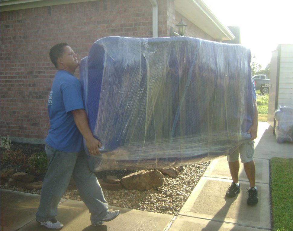 two man carrying big thing