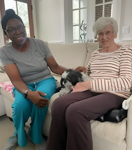 two women are sitting on a couch holding hands .