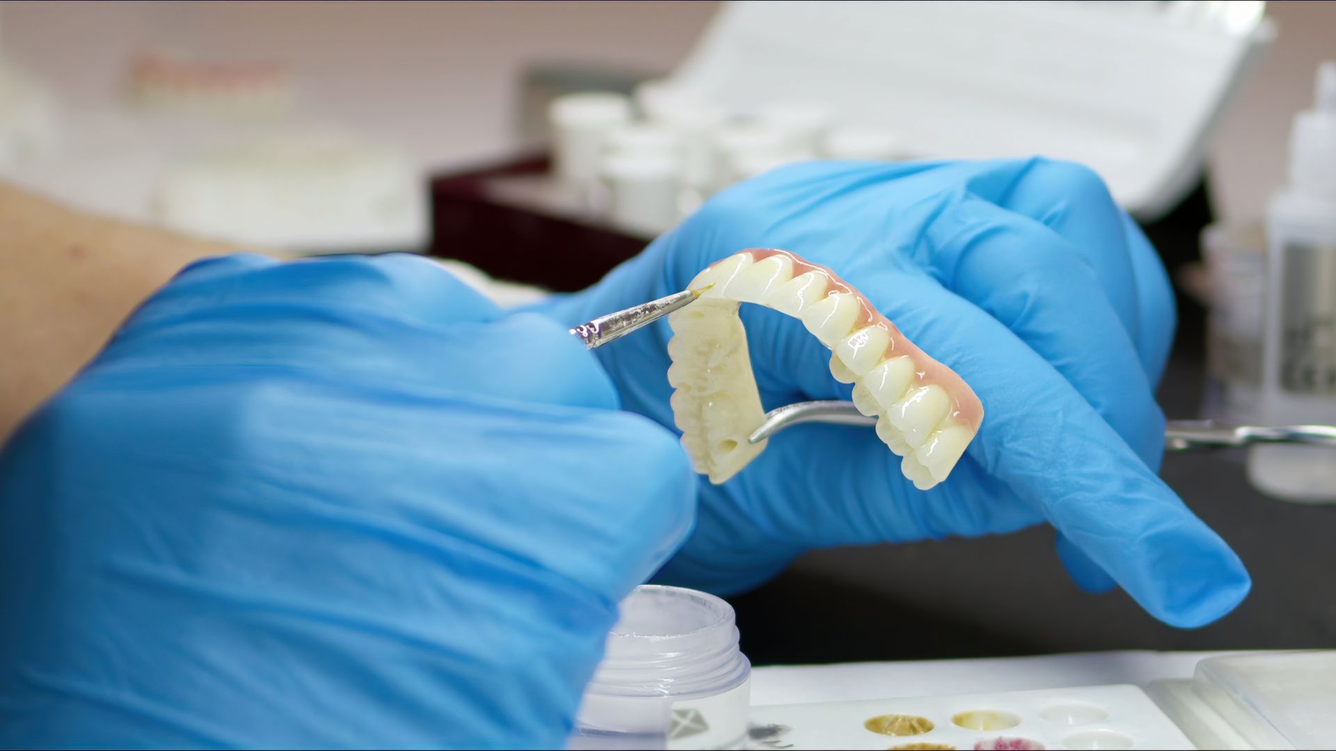 Gloved hands holding a dental mold in a clinic setting Gloved hands holding a dental mold in a clinic setting
