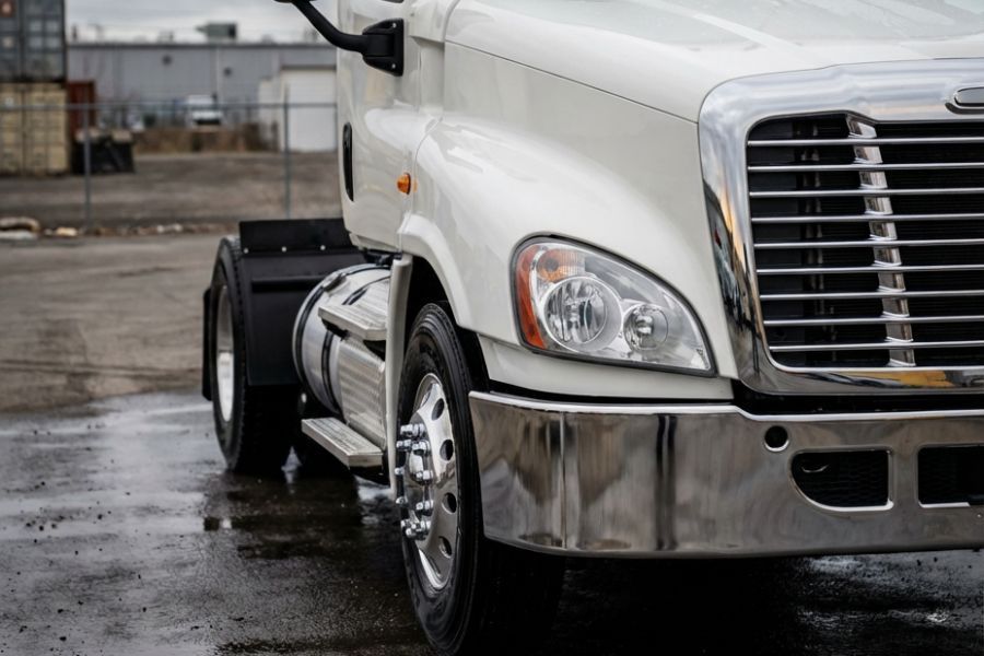 Clean white day cab truck with polished wheel, chrome hub, and lug nuts clearly visible after washing