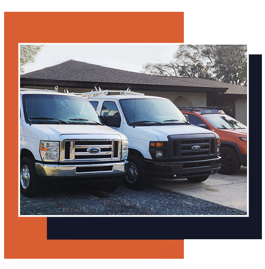 Two parked white vans and an orange car in front of a building, framed by orange and navy blocks