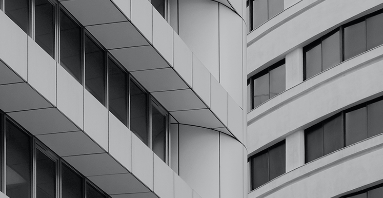 Black-and-white view of a modern curved office building facade with rows of windows