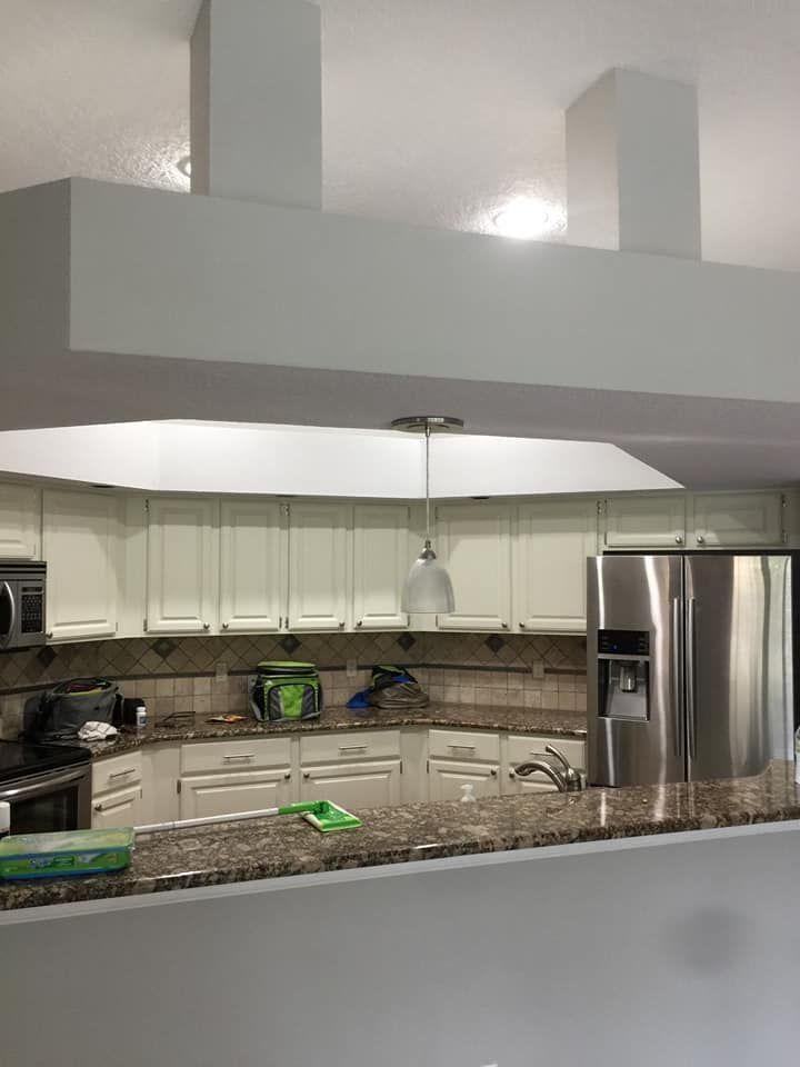 Modern kitchen with white cabinets, granite island, stainless appliances, and pendant lights