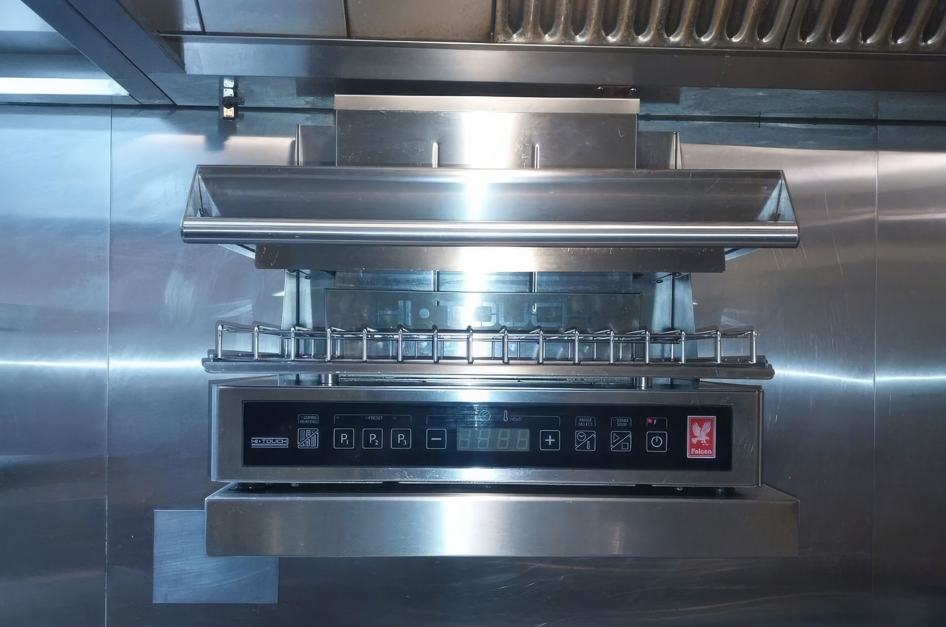Stainless steel commercial kitchen range hood with control panel.