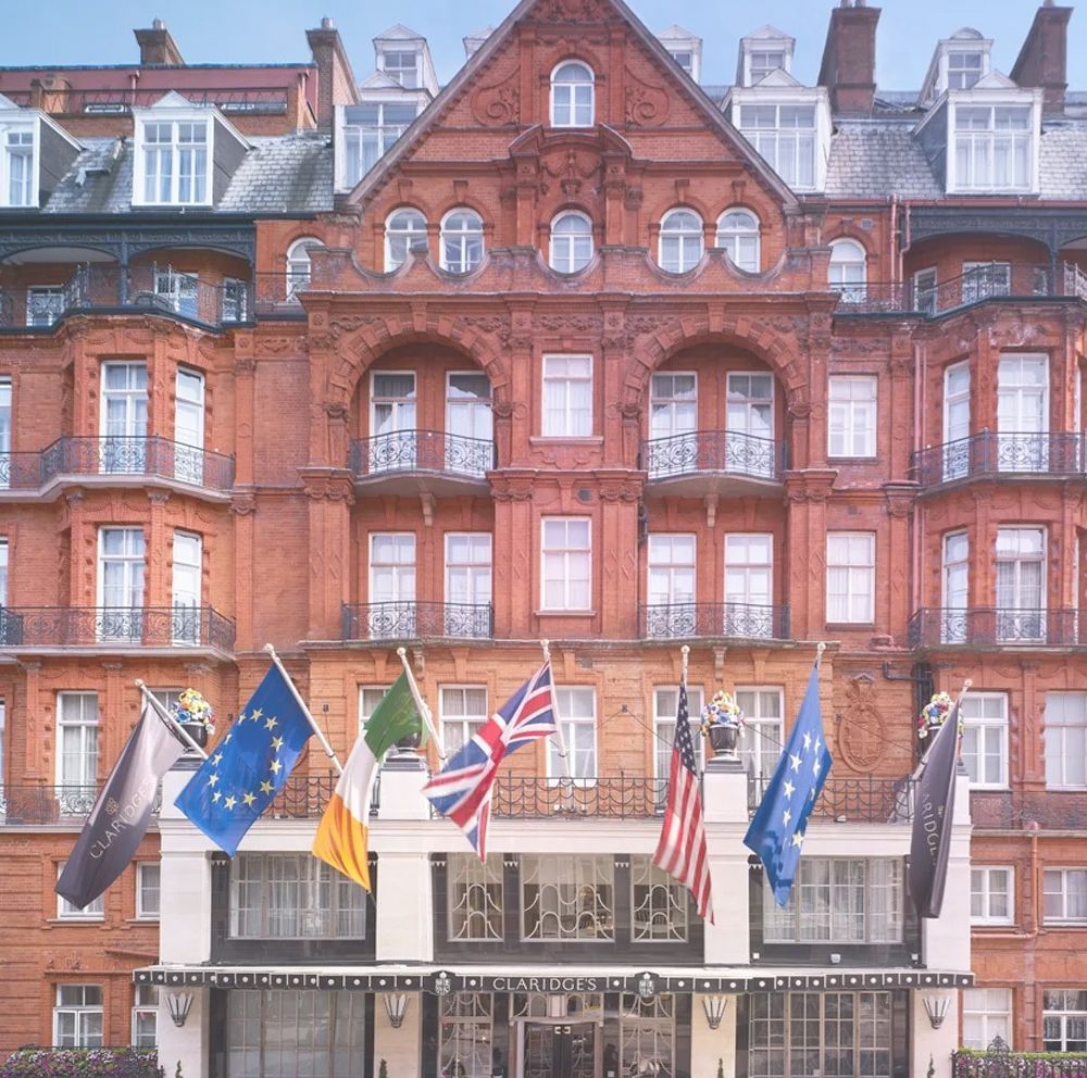 Red brick building with flags of EU, Ireland, UK, and US; hotel entrance.