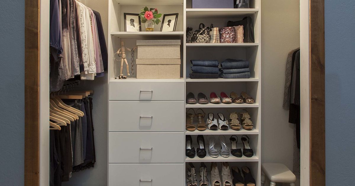 Walk-in closet with white drawers, shelves, hanging clothes, shoes, and folded items