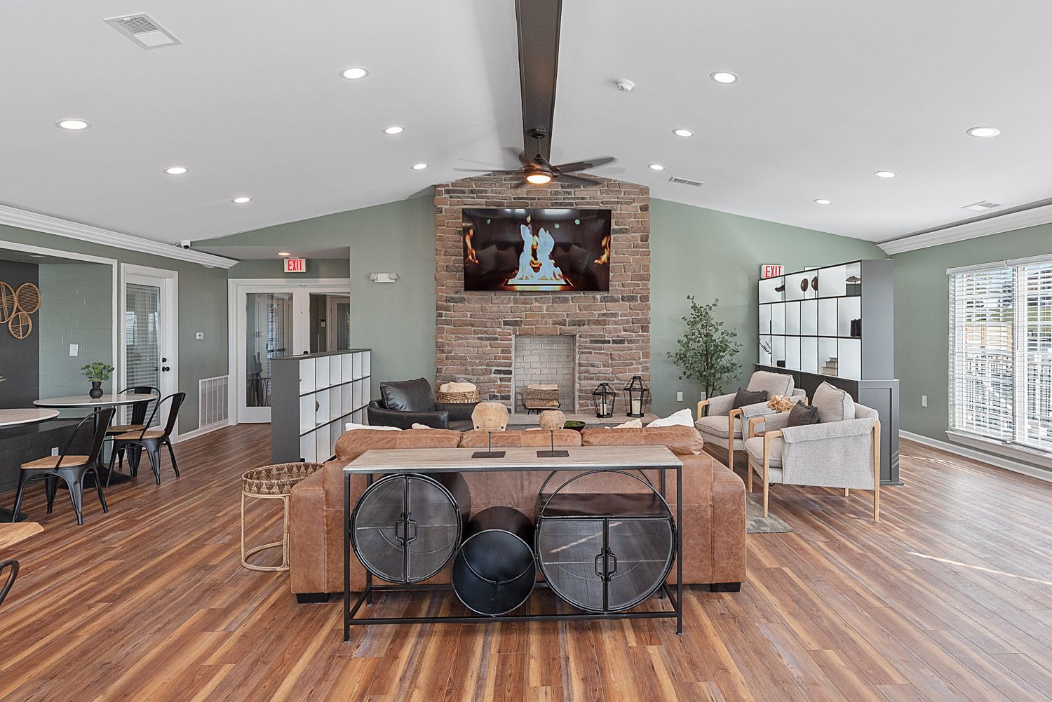 A living room with hardwood floors , a fireplace and a flat screen tv.