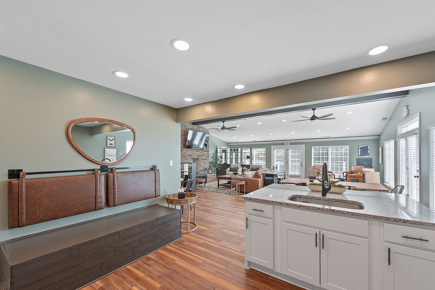 A kitchen with a sink , cabinets , a bench and a mirror.