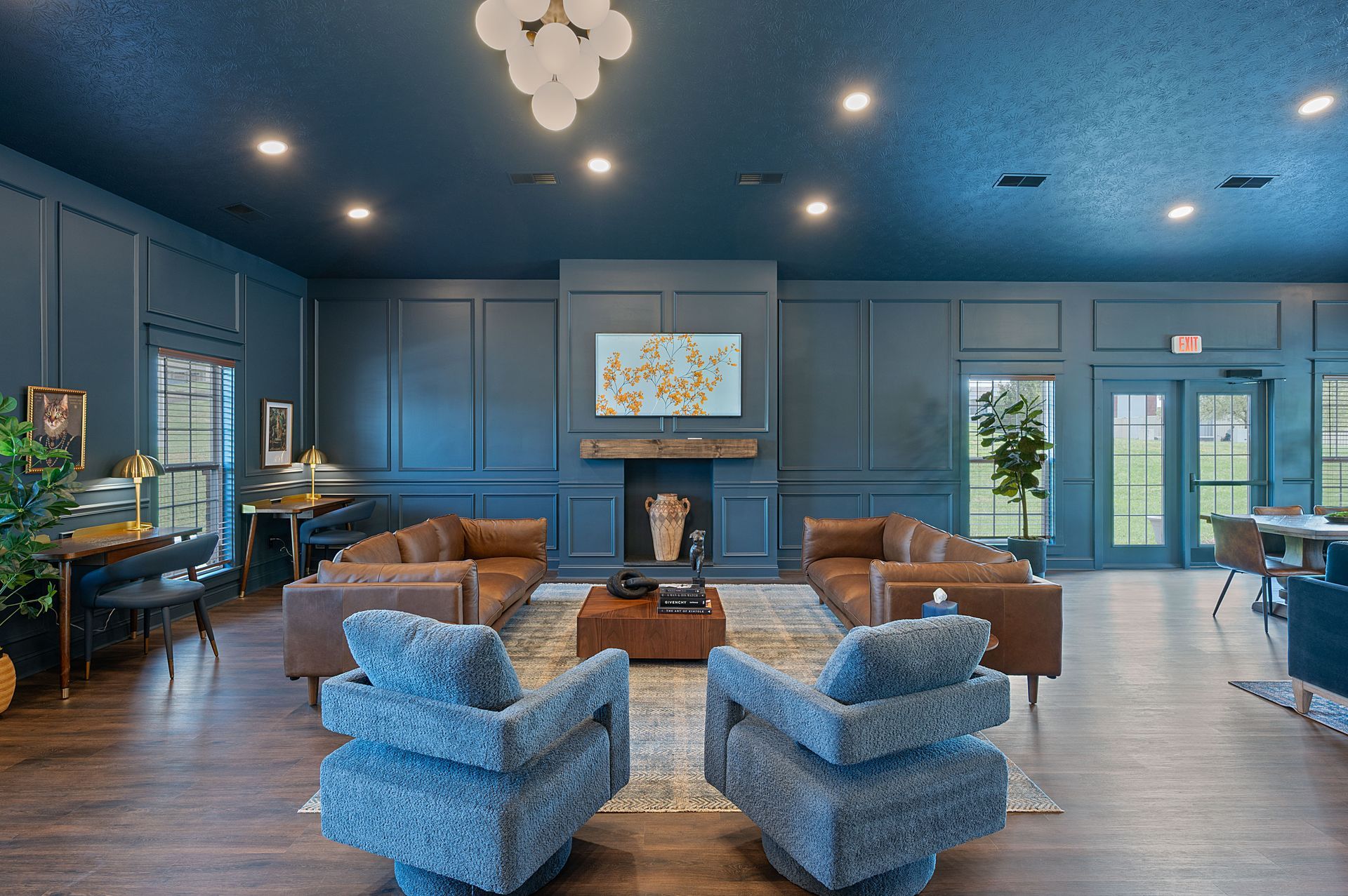 A large room with sofa and chairs in front of a fireplace