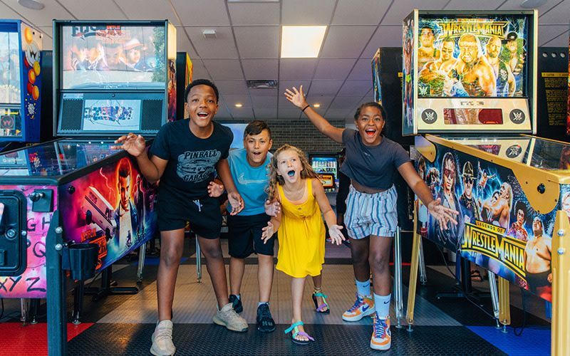A group of children are posing for a picture in an arcade.