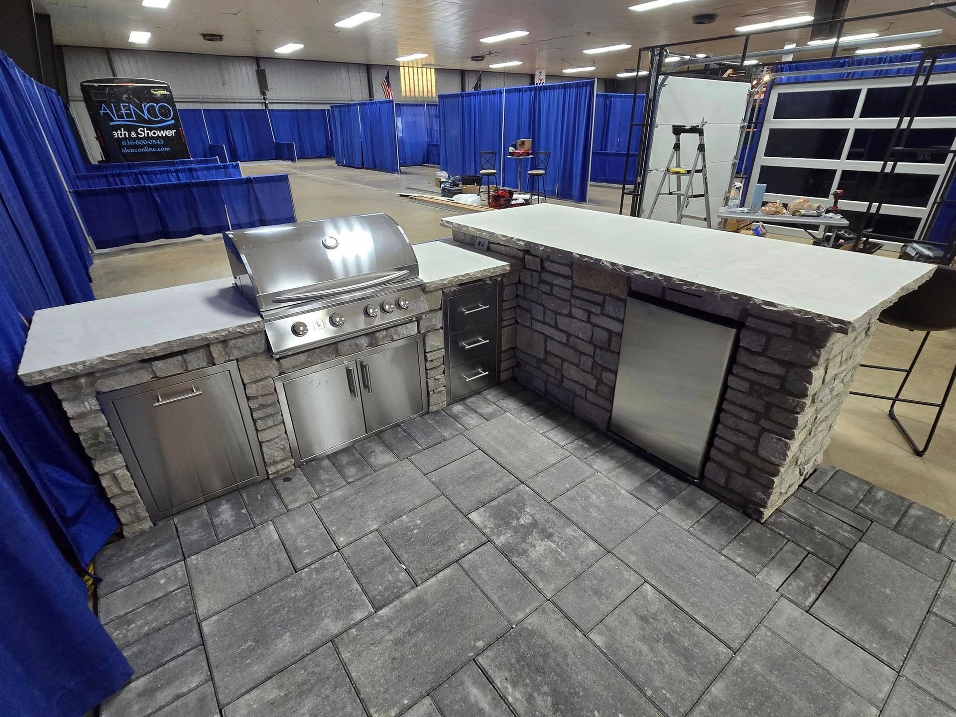 A kitchen with a grill and a counter in a room with blue curtains.